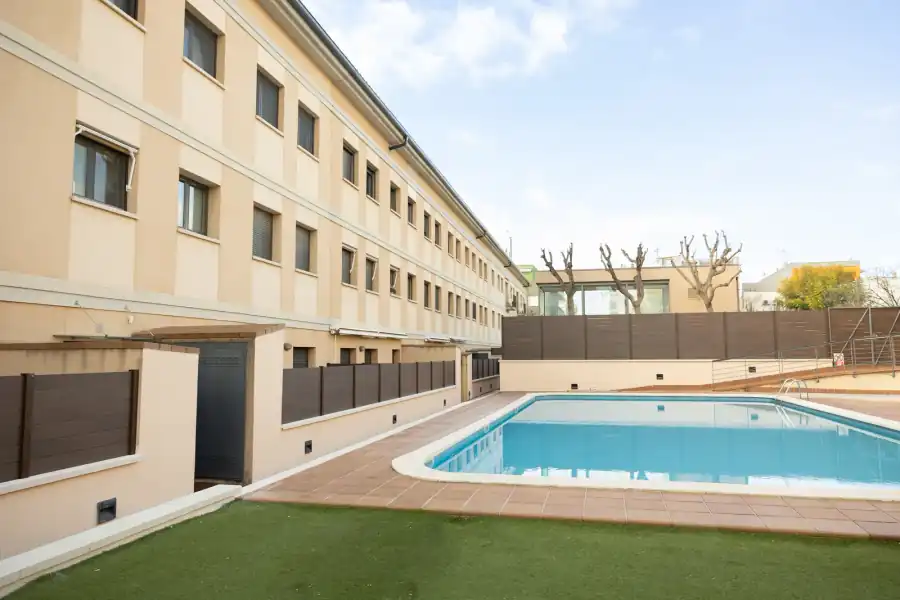 Vallado de madera sintética color roble en zona comunitaria con piscina